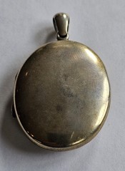 Antique gold tone oval locket with etched intricate script monogram and bail