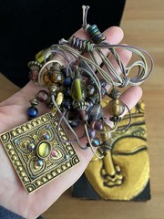 Vintage-style beaded necklace with a square, metal pendant paired with earrings
