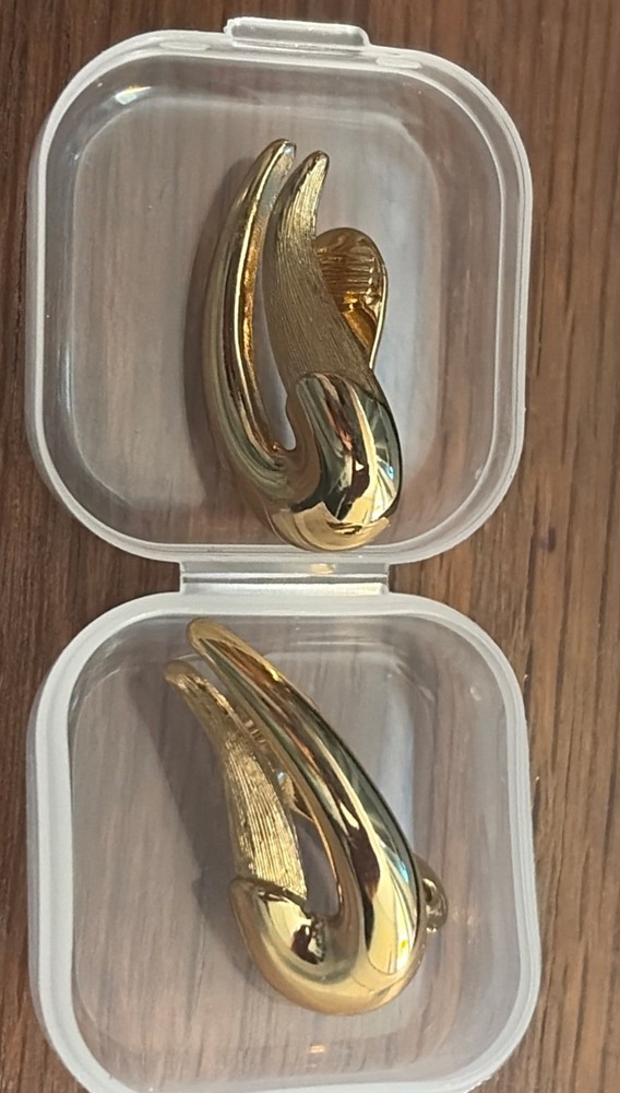 Signed Vintage Monet clip on earring in gold tone with texture. 1 x .5 inches.