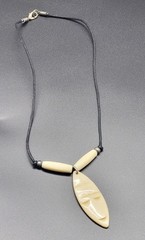 Vintage 18″ vinyl necklace with shield shape bone face pendant