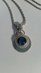Blue Tiger Eye Cabochon style pendant with a convex formed silver toned reverse