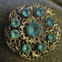 VTG Brooch featuring blue rhinestones set in a silver-tone filigree metal.