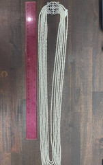 White multi-strand pearl necklace features a detailed rhinestone-set clasp