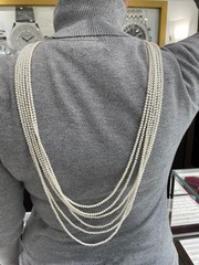 White multi-strand pearl necklace features a detailed rhinestone-set clasp