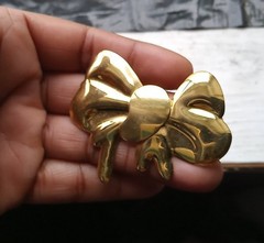 Vintage-style Bow Brooch features a polished, shiny gold-tone