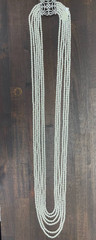 White multi-strand pearl necklace features a detailed rhinestone-set clasp