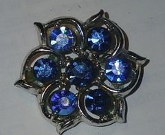 Blue crystals in silver metal setting round brooch/pin
