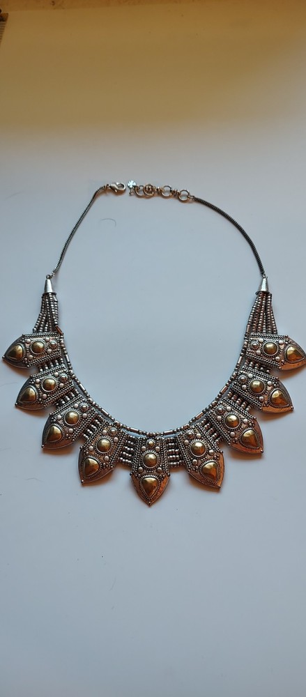 Bohemian design necklace with curved row of repeating leaf-or shield- shape pane