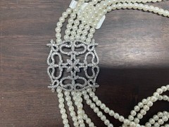White multi-strand pearl necklace features a detailed rhinestone-set clasp