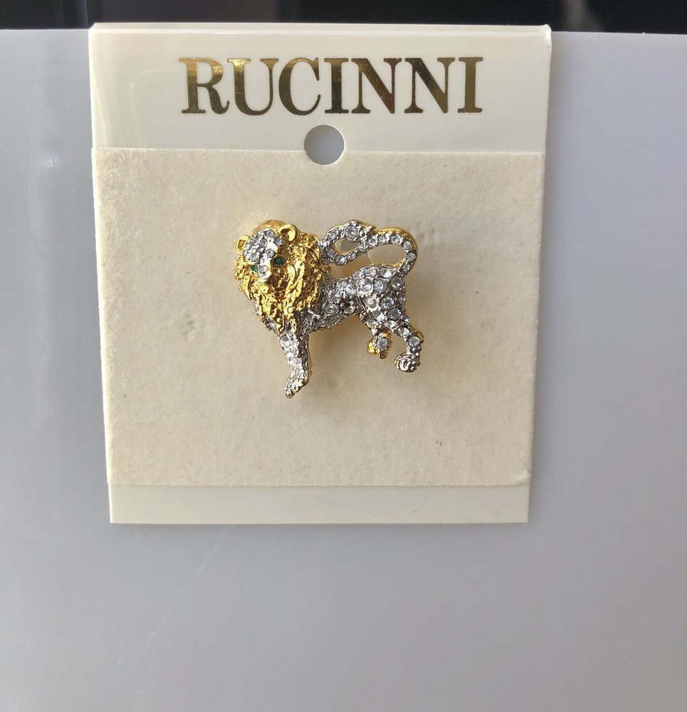Rucinni Gold and White Lion brooch with White crystals and two green eyes.
