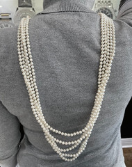 White multi-strand pearl necklace features a detailed rhinestone-set clasp