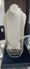 White multi-strand pearl necklace features a detailed rhinestone-set clasp