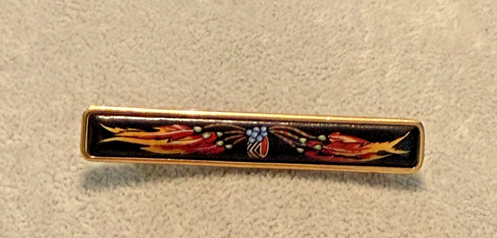 vintage Hermes enamel bar brooch featuring a vibrant red, blue, and gold JB1