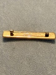 vintage Hermes enamel bar brooch featuring a vibrant red, blue, and gold JB1