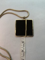 Large gold tone snake chain there’s a large square black suede pendant￼