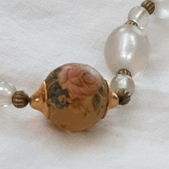 Vintage unbranded clear lucite oval beaded necklace w/central floral bead.