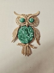 vintage articulated owl pendant necklace features a gold-tone finish, green faux