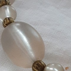 Vintage unbranded clear lucite oval beaded necklace w/central floral bead.