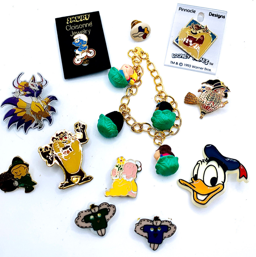 VTG LOT 12 CARTOON CHARACTER BRAND PINS – WARNER BROS, LOONEY TOONS, SMURF, AVON