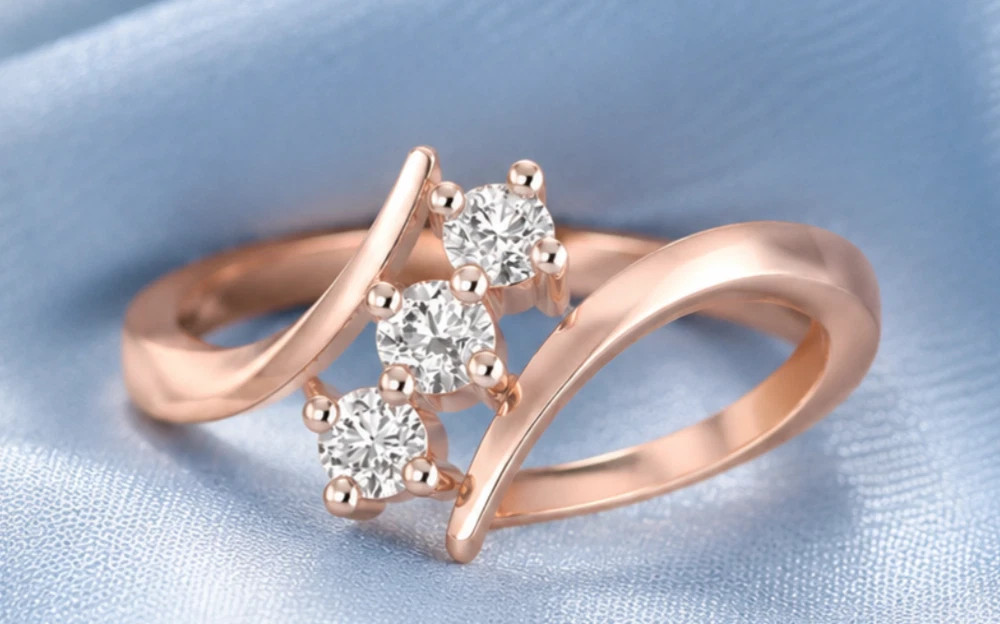 0.18TCW Round Cut White Moissanite Trilogy Swirl Design Ring In 10K Rose Gold FN