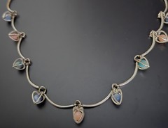 9 multicolor heart caged bead charms on a silvertone necklace