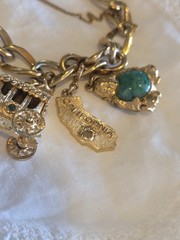 vintage Monet gold-tone charm bracelet features multiple detailed charms
