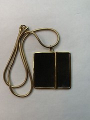 Large gold tone snake chain there’s a large square black suede pendant￼