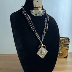 Vintage-style beaded necklace with a square, metal pendant paired with earrings