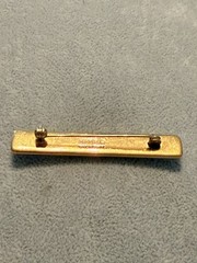 vintage Hermes enamel bar brooch featuring a vibrant red, blue, and gold JB1