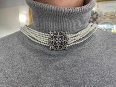 White multi-strand pearl necklace features a detailed rhinestone-set clasp