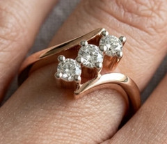 0.18TCW Round Cut White Moissanite Trilogy Swirl Design Ring In 10K Rose Gold FN