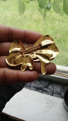 Vintage-style Bow Brooch features a polished, shiny gold-tone