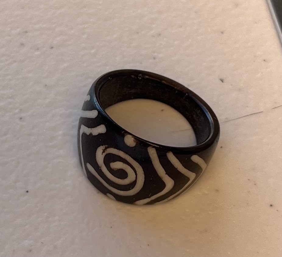 Black acrylic ring about size 3 with ivory-colored storm spiral