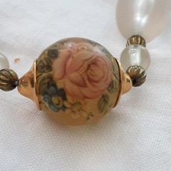 Vintage unbranded clear lucite oval beaded necklace w/central floral bead.