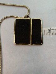 Large gold tone snake chain there’s a large square black suede pendant￼