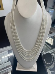 White multi-strand pearl necklace features a detailed rhinestone-set clasp