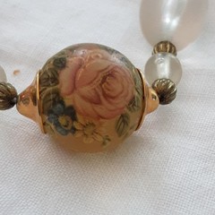 Vintage unbranded clear lucite oval beaded necklace w/central floral bead.