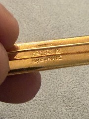 vintage Hermes enamel bar brooch featuring a vibrant red, blue, and gold JB1