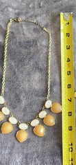 Vintage Bib necklace featuring orange and off-white acrylic stones. 21″