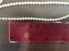 White multi-strand pearl necklace features a detailed rhinestone-set clasp