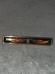 vintage Hermes enamel bar brooch featuring a vibrant red, blue, and gold JB1