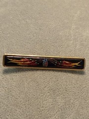 vintage Hermes enamel bar brooch featuring a vibrant red, blue, and gold JB1