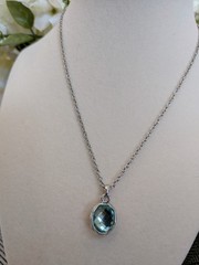 vintage Cookie Lee silver necklace with a faceted aqua blue crystal pendant.