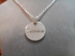 16″ vintage chain with a rhinestone bail holding a “survivor” charm