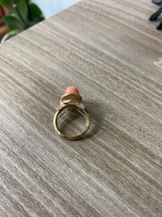 Avon vintage gold toned ring showcasing a single faux coral-colored bead.