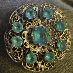 VTG Brooch featuring blue rhinestones set in a silver-tone filigree metal.
