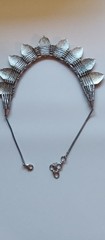 Bohemian design necklace with curved row of repeating leaf-or shield- shape pane