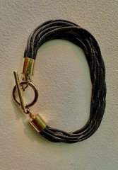 multi-strand bracelet features black and gold tone textured cords